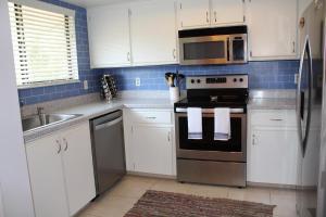 a kitchen with white cabinets and a stainless steel appliances at Sea Woods Large 1 Bedroom Condo And A Whole Lot Of Amenities! in New Smyrna Beach