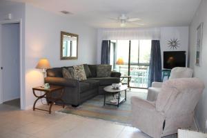 a living room with a couch and a chair at Sea Woods Large 1 Bedroom Condo And A Whole Lot Of Amenities! in New Smyrna Beach