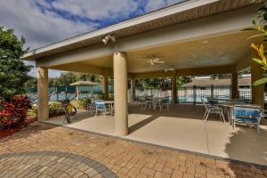 a covered patio with chairs and tables and chairs at Sea Woods Large 1 Bedroom Condo And A Whole Lot Of Amenities! in New Smyrna Beach