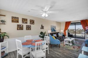 a living room with a table and chairs and a couch at The Sea Esta At Coastal Waters in New Smyrna Beach