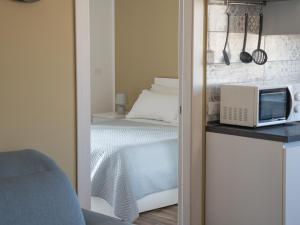a bedroom with a bed and a microwave on a counter at Central Station Home - Fanale Rentals in Palermo