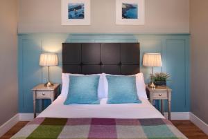 a bedroom with a large bed with two nightstands and two lamps at Armada Cottages in Spanish Point