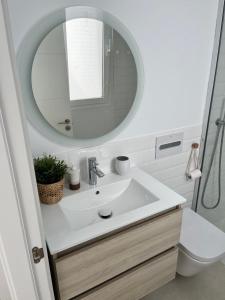 uma casa de banho com um lavatório branco e um espelho. em Casa el Timple em Costa Teguise