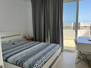 a bedroom with a bed and a large window at Casa el Timple in Costa Teguise