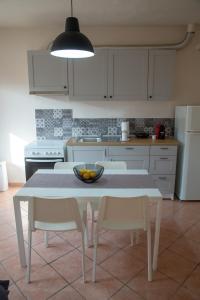 a kitchen with a table with chairs and a bowl of fruit on it at Castle's Soul in Kavala