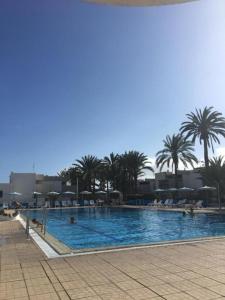 a large swimming pool with palm trees in the background at Vivienda Ida - Costa Del Silencio Tenerife in Costa Del Silencio