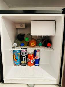 um frigorífico cheio de bebidas e latas de refrigerante em Le Prince Arica em Arica