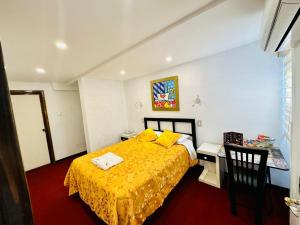 een slaapkamer met een geel bed en een tafel en stoelen bij Le Prince Arica in Arica +18 foto's