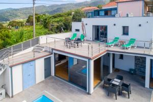 an aerial view of a house with a deck and chairs at Casa Santi Stefany in Arco da Calheta