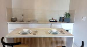 a kitchen island with two cups and plates on it at Lemon Tree Manor - Scandi Suite in Groblersdal