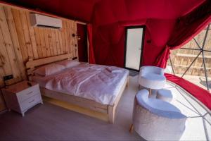 1 dormitorio con 1 cama en una tienda roja en Besega Bungalow, en Uzungöl