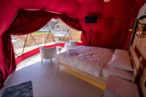 1 dormitorio con 1 cama en una tienda roja en Besega Bungalow, en Uzungöl