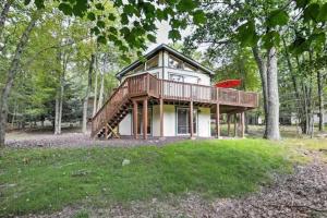 a house with a deck on top of a field at Woodland Escape-0.6Mile to Lake Beach Pet Friendly in Lake Harmony