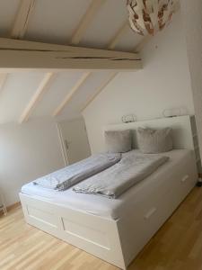 ein weißes Bett in einem Zimmer mit einer Decke in der Unterkunft Ferienwohnung Königsschloss in Schwangau