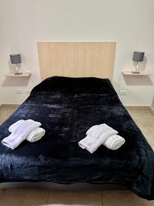 a bed with two pairs of mens socks on it at Departamento temporal 2 Shopping in Villa Nueva