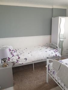 a bedroom with a white bed with flowers on it at Summer Days in Camber