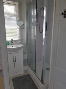 een badkamer met een douche en een wastafel bij Summer Days in Camber