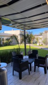 a patio with chairs and a table and a table and chairs at Apart IMEB spa & wellness in Río Cuarto