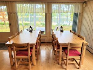 a dining room with two wooden tables and chairs at Lastun Paikat Päätalo in Puhos