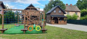 un parque infantil frente a una casa con parque infantil en HARCÓWKA en Złoty Stok