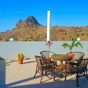 a patio with a table and chairs and a mountain at Splanada poilon in Assomada