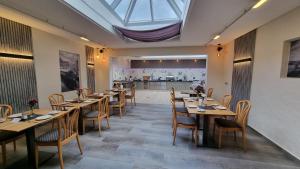 a restaurant with wooden tables and chairs and a skylight at Hotel Zum Anker-THULLs Restaurant in Neumagen-Dhron