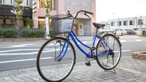 Una bicicleta azul estacionada en una acera junto a una calle en Sunrise Inn - Vacation STAY 75380v, en Kaizuka