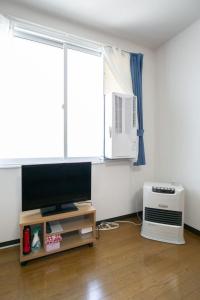 uma sala de estar com uma televisão e uma janela em Dream Misono - Vacation STAY 14776 em Sapporo