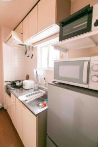 uma pequena cozinha com frigorífico e micro-ondas em Dream Misono - Vacation STAY 14776 em Sapporo