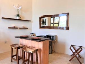 a room with a counter with stools and a mirror at Villa Amor in Sayulita