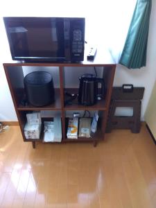 a microwave on a shelf in a room at Restful Tsukuda - Vacation STAY 14829 in Aomori