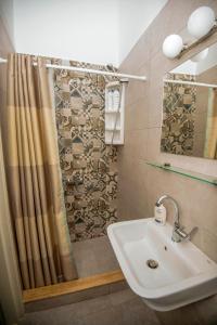 a bathroom with a shower curtain and a sink at Lithos apartments in Kalymnos