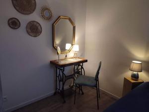 um toucador com um espelho e uma cadeira num quarto em Appartement cosy au pied des Halles,Le Rossini em Narbona