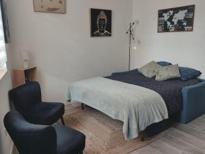 um quarto com uma cama e uma cadeira em Appartement cosy au pied des Halles,Le Rossini em Narbona