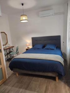 um quarto com uma cama com almofadas azuis e uma mesa em Appartement cosy au pied des Halles,Le Rossini em Narbonne