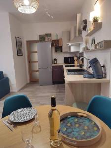 Una botella de vino sentada en una mesa en una cocina en Appartement cosy au pied des Halles,Le Rossini, en Narbona