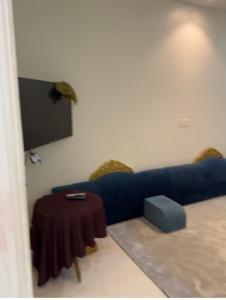 a living room with a blue couch and a table at شقة مفروشه ب٣ غرف in Sūq al Aḩad