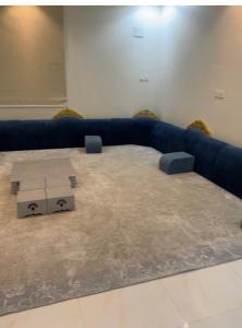 a living room with a blue couch and a table at شقة مفروشه ب٣ غرف in Sūq al Aḩad