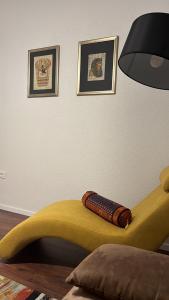 a bedroom with a yellow bed with a lamp and pictures at Apartment Jadera in Zadar