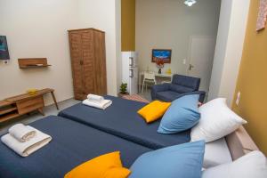 sypialnia z dużym łóżkiem z niebieskimi i żółtymi poduszkami w obiekcie Lithos apartments w mieście Kalimnos
