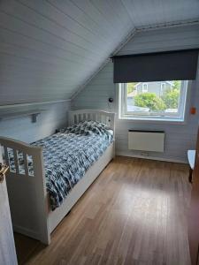 um quarto com uma cama num quarto com uma janela em Trivelig hus sentralt på Storslett em Storslett