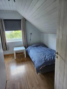 a small bedroom with a bed and a window at Trivelig hus sentralt på Storslett in Storslett