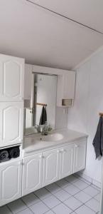 a white bathroom with a sink and a mirror at Trivelig hus sentralt på Storslett in Storslett