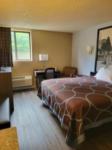 Pokój hotelowy z dużym łóżkiem i biurkiem w obiekcie Super 8 by Wyndham Sullivan w mieście Sullivan