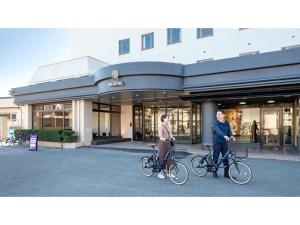 two people riding bikes in front of a building at EN HOTEL Ise - Vacation STAY 89611v in Ise