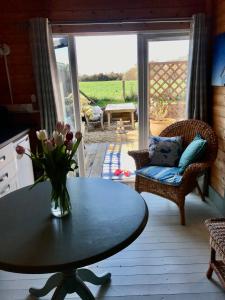 un soggiorno con un vaso di fiori su un tavolo di The Log Cabin a Wimborne Minster