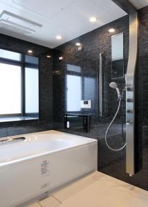 a bathroom with a large tub and a shower at Urban Grace Hiroshima 1301 - Vacation STAY 14847 in Hiroshima