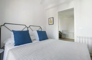 マドリードにあるGenteel Home Cava Bajaの白いベッドルーム(青い枕のベッド付)