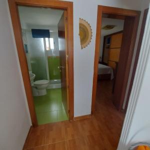 a bathroom with a toilet and a door to a room at Apartamento acogedor Córdoba in Córdoba