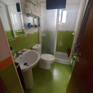 La salle de bains est pourvue de toilettes blanches et d'un lavabo. dans l'établissement Apartamento acogedor Córdoba, à Cordoue